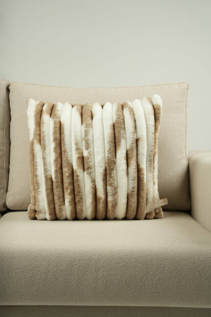 Coussin beige et blanc en fausse fourrure
