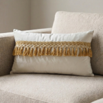 Coussin rectangulaire grège avec pompons dorés